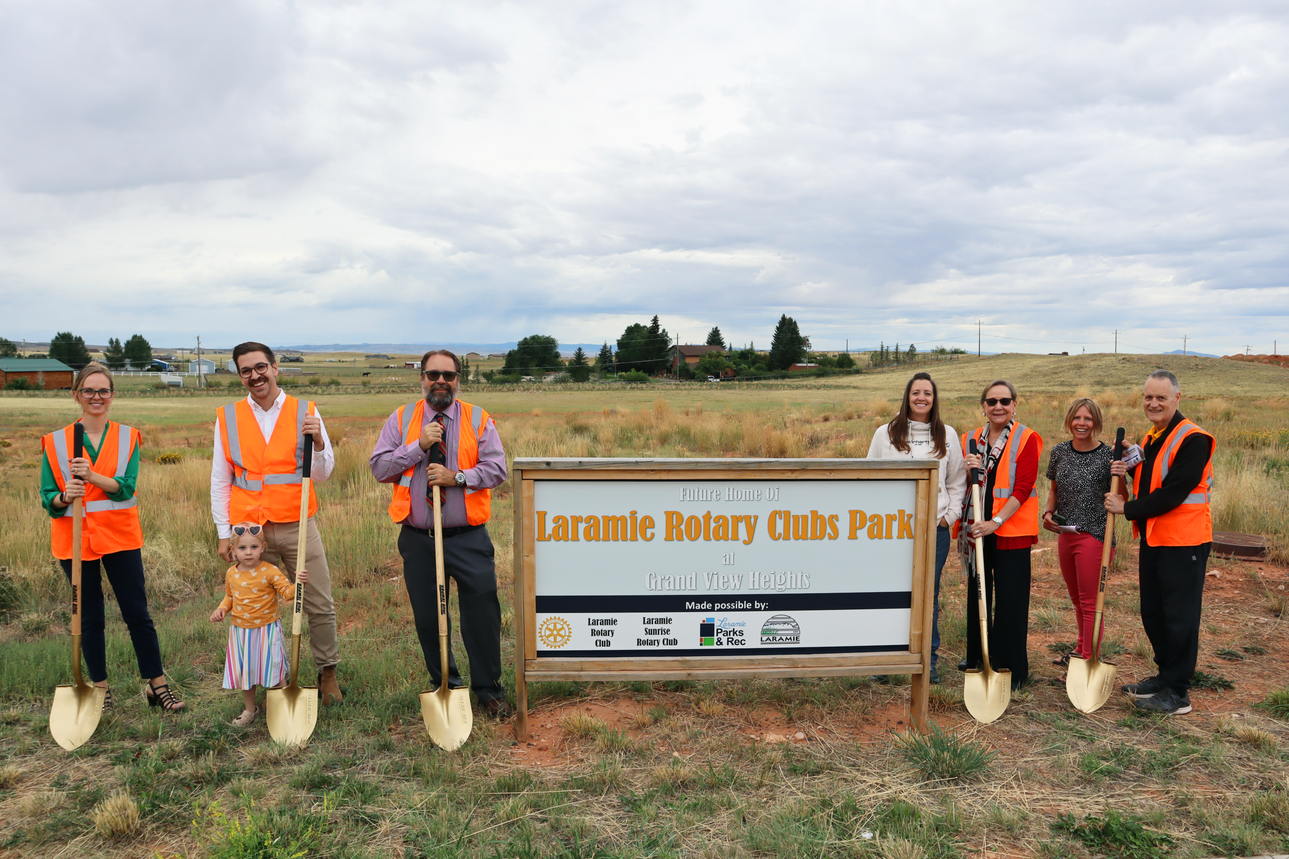 workers standing the Rotary Clubs Park sign