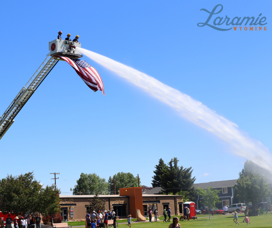 fire fighters spraying water from fire truck over park